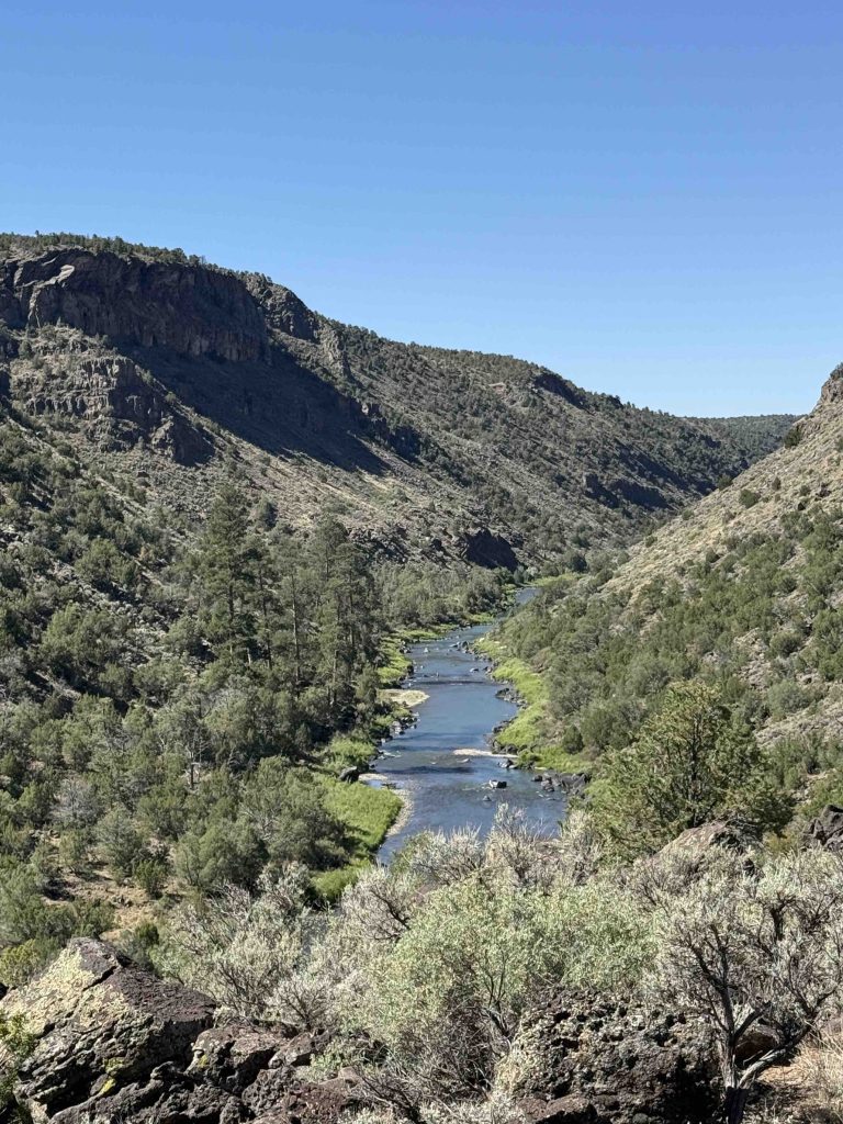 Overlook of a northern New Mexico river canyon, the river winding through steep high-country terrain
