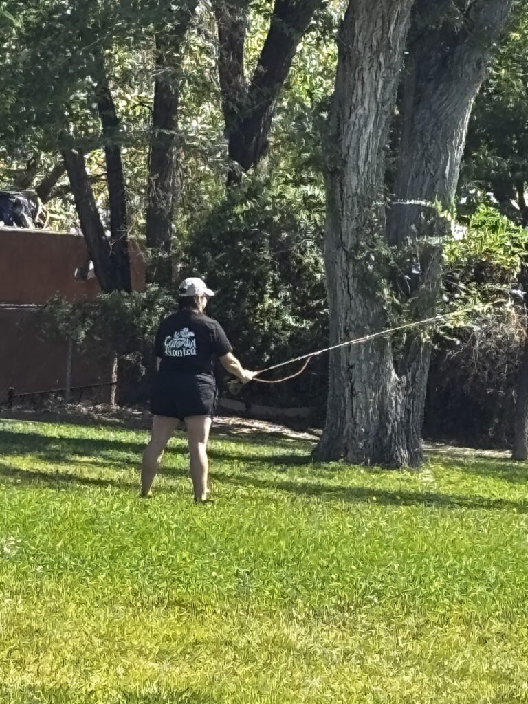 Participant working on her casting stroke on the park lawn