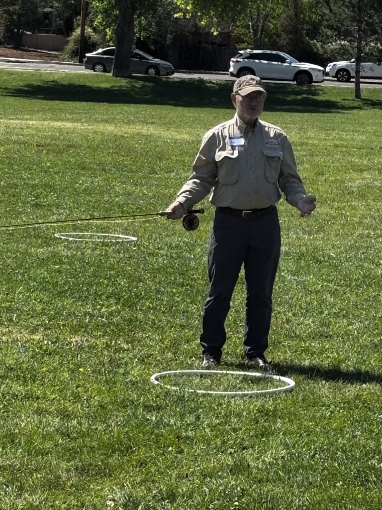 Instructor demonstrating a casting technique beside a practice hoop